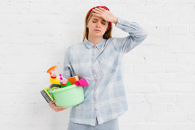 Mujer cansada de limpiar con productos agresivos